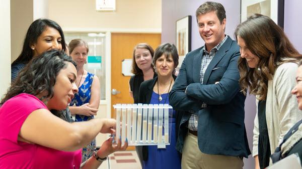 Photo of clinician showing off sugar levels in test tubes